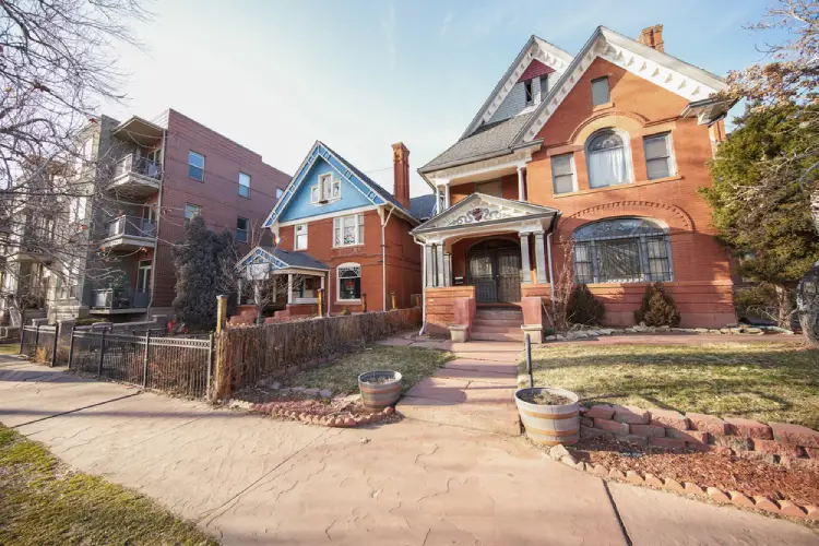 Historic brick homes with Victorian architecture in Denver’s Capitol Hill neighborhood, showcasing narrow walk-ups and classic design.