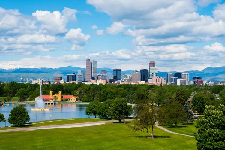 Scenic view of Denver skyline with parks, mountains, and city buildings, highlighting how different neighborhoods impact moving logistics.
