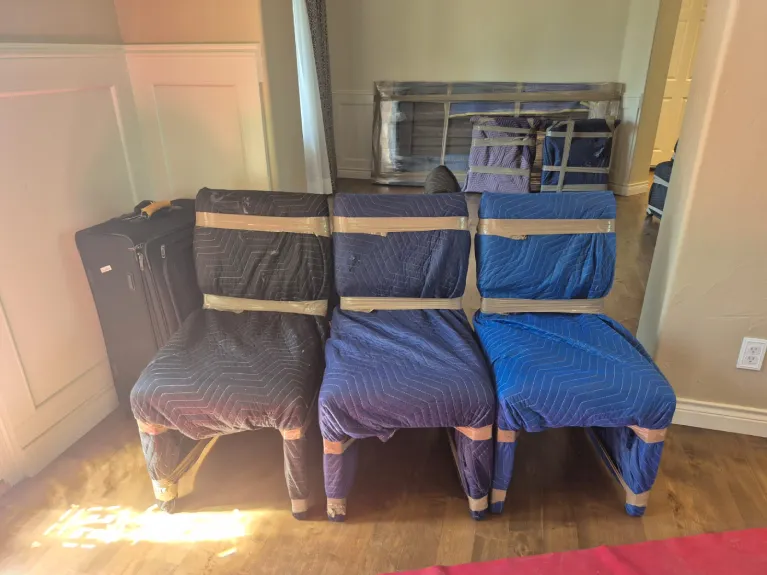 Furniture wrapped in moving blankets and secured with tape, showing how professional Denver movers protect belongings during high-rise moves.
