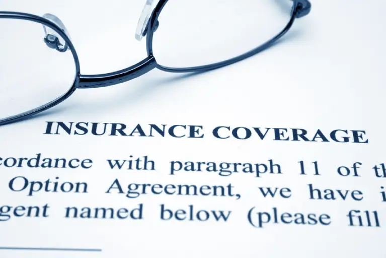 Close-up of an insurance coverage document with eyeglasses, symbolizing the importance of submitting a COI for Denver high-rise moves.